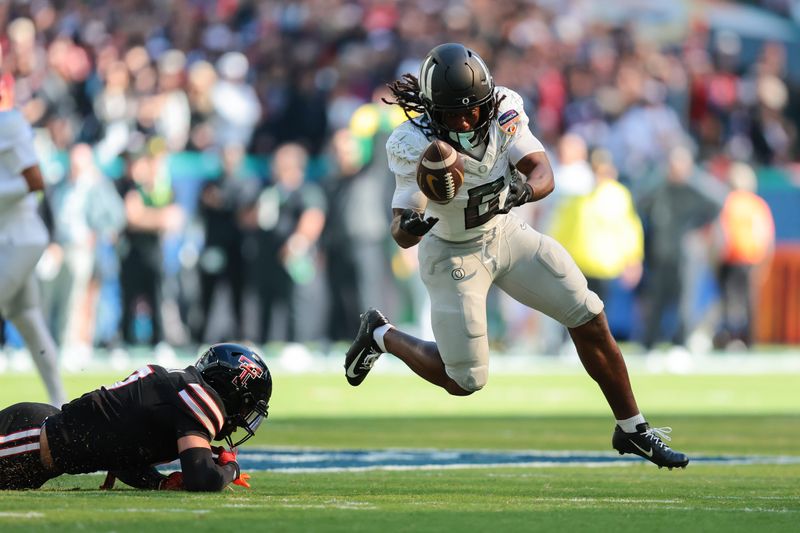 Jan 1, 2026; Miami Gardens, FL, USA; Oregon Ducks running back Noah Whittington (6) carries the ball as Texas Tech Red Raiders defensive back Brenden Jordan (7) defends during the first half of the 2025 Orange Bowl and quarterfinal game of the College Football Playoff at Hard Rock Stadium. Mandatory Credit: Sam Navarro-Imagn Images