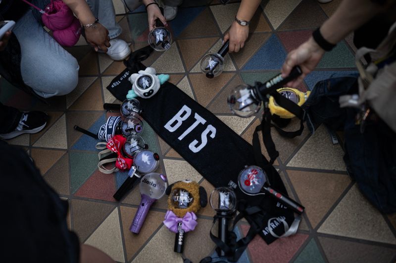 Fans of Korean boy band BTS put down their glow sticks next to a banner as they wait in line at Tokyo Dome before the start of the first BTS World Tour 'Arirang' in Tokyo on April 17, 2026. Tens of thousands of fans awaited excitedly outside the landmark Tokyo stadium to watch BTS in their first concert outside South Korea after the K-pop megastars kicked off their world tour.