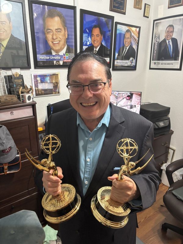 Just retired newsman Hector Urrutia at his home holding two of his four Emmy's for in-depth reporting broadcast news.