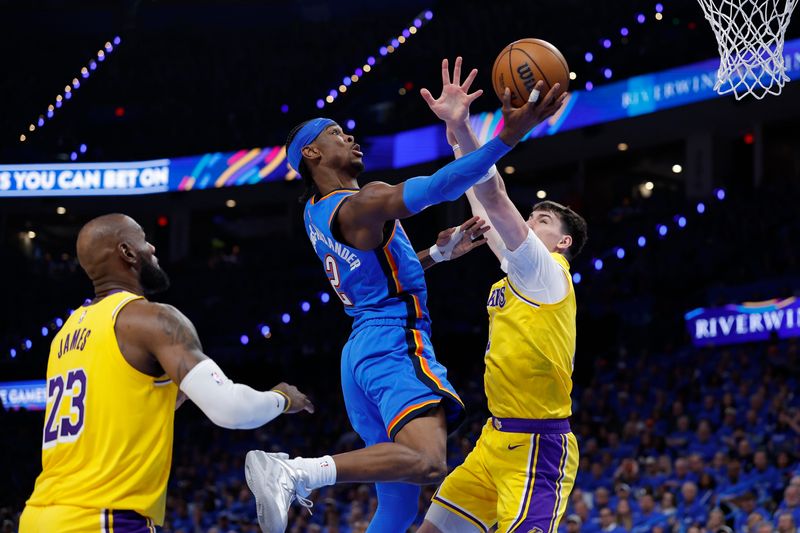 Oklahoma City Thunder guard Shai Gilgeous-Alexander (2) goes up for a basket as Los Angeles Lakers forward Jake LaRavia (12) defends during Game 1 of the second round of the 2026 NBA Playoffs at Paycom Center in Oklahoma City, Oklahoma.