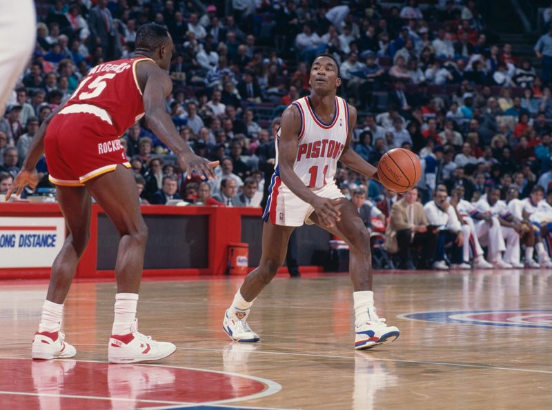 Isiah Thomas #11, Point Guard for the Detroit Pistons dribbles the basketball as #15 Mitchell Wiggins, Shooting Guard for the Houston Rockets faces to block during their NBA Central Division basketball game on 27th February 1990 at the Palace of Auburn Hills arena in Auburn Hills, Michigan, United States. The Pistons won the game 106 - 102. (Photo by Allsport/Getty Images)