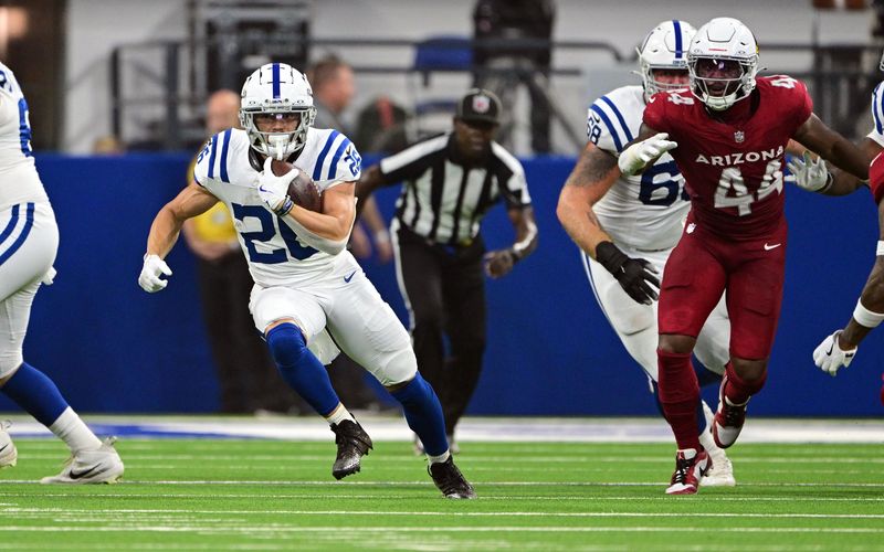 Aug 17, 2024; Indianapolis, Indiana, USA; Indianapolis Colts running back Evan Hull (26) runs the ball past Arizona Cardinals linebacker Owen Pappoe (44) during the first quarter at Lucas Oil Stadium. Mandatory Credit: Marc Lebryk-USA TODAY Sports