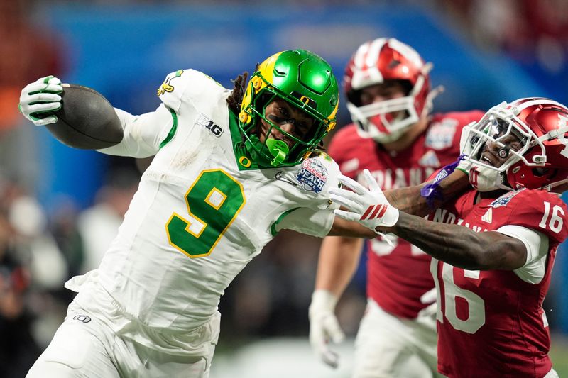 Jan 9, 2026; Atlanta, GA, USA; Oregon Ducks tight end Jamari Johnson (9) stiff arms Indiana Hoosiers defensive back Jah Jah Boyd (16) during the fourth quarter the 2025 Peach Bowl and semifinal game of the College Football Playoff at Mercedes-Benz Stadium. Mandatory Credit: Dale Zanine-Imagn Images