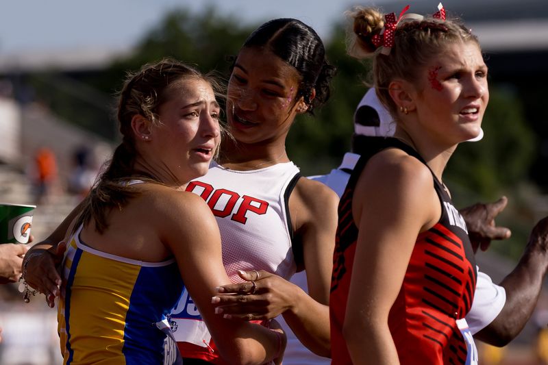 Veribest’s Chloe Becker hugs Loop’s Kamryn Dyck after they cross the finish line in the girls 100-meter dash during the Class 1A UIL State track and field meet on May 16, 2026, at Mike A. Myers Stadium in Austin, Texas.