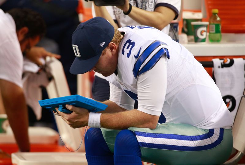 Aug 28, 2014; Arlington, TX, USA; Dallas Cowboys quarterback Brandon Weeden (3) looks at a Microsoft Surface tablet on the bench against the Denver Broncos at AT&T Stadium. Denver beat Dallas 27-3. Mandatory Credit: Tim Heitman-USA TODAY Sports