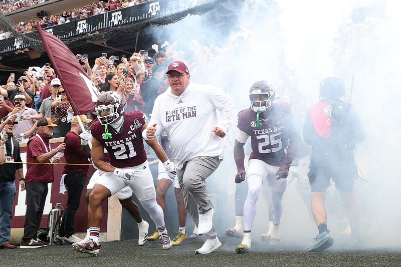 Dec 20, 2025; College Station, TX, USA; Texas A&M Aggies head coach Mike Elko takes the field prior to the game against the Miami Hurricanes during the first round of the CFP National Playoff at Kyle Field. Mandatory Credit: Maria Lysaker-Imagn Images