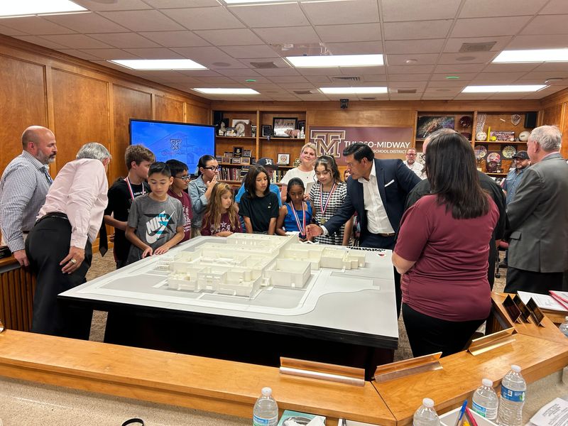 Architect Sergio Láinez explains a model of the new Tuloso-Midway Junior High School, which will begin construction this summer, to students and school district leaders on May 18, 2026.