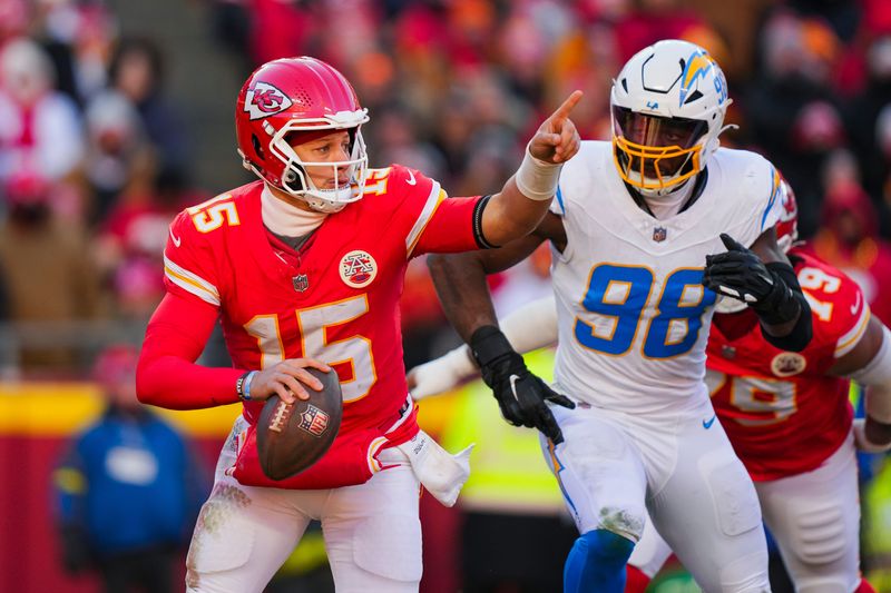 Dec 14, 2025; Kansas City, Missouri, USA; Kansas City Chiefs quarterback Patrick Mahomes (15) scrambles against Los Angeles Chargers linebacker Odafe Oweh (98) during the second half at GEHA Field at Arrowhead Stadium. Mandatory Credit: Jay Biggerstaff-Imagn Images