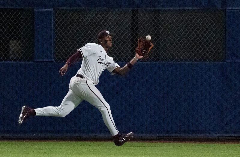 Texas A&M Aggies' Jorian Wilson (23) catches a fly ball as Auburn Tigers take on Texas A&M Aggies during the SEC baseball tournament at Hoover Metropolitan Stadium at Legacy Arena in Hoover, Ala. on Friday, May 22, 2026. Auburn Tigers defeated Texas A&M Aggies 7-0.