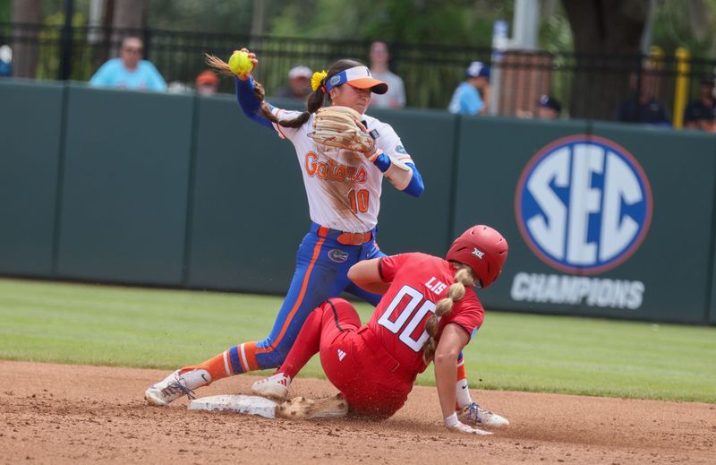 Florida infielder Gabi Comia (10) gets Texas Tech infielder Jackie Lis (00) out and throws for the double play during the super regional game of the NCAA Division 1 softball championship at Katie Seashole Pressly Stadium in Gainesville, FL on Friday, May 22, 2026. [Alan Youngblood/Gainesville Sun]