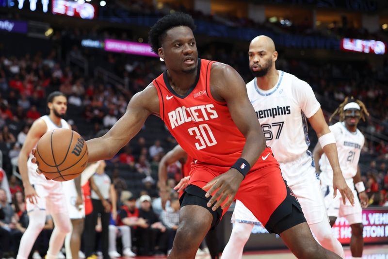 Apr 12, 2026; Houston, Texas, USA; Houston Rockets center Clint Capela (30) gets control of the ball away from Memphis Grizzlies forward Taj Gibson (67) during the first quarter at Toyota Center. Mandatory Credit: Troy Taormina-Imagn Images