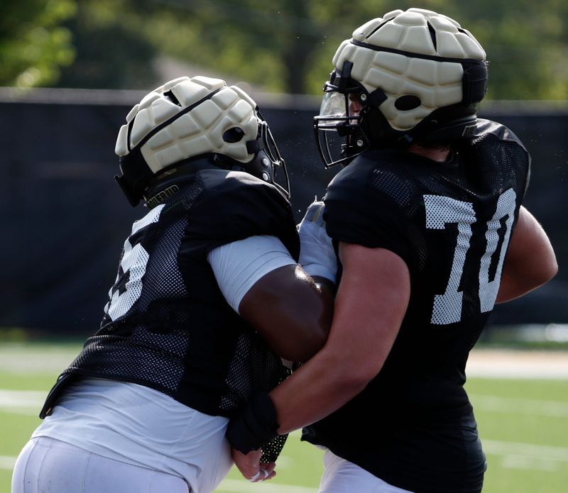 Purdue Boilermakers offensive lineman DJ Wingfield (55) and Purdue Boilermakers offensive lineman Max Parrott (70) run a drill Wednesday, Aug. 21, 2024, during Purdue football practice at Bimel Outdoor Practice Complex in West Lafayette, Ind.