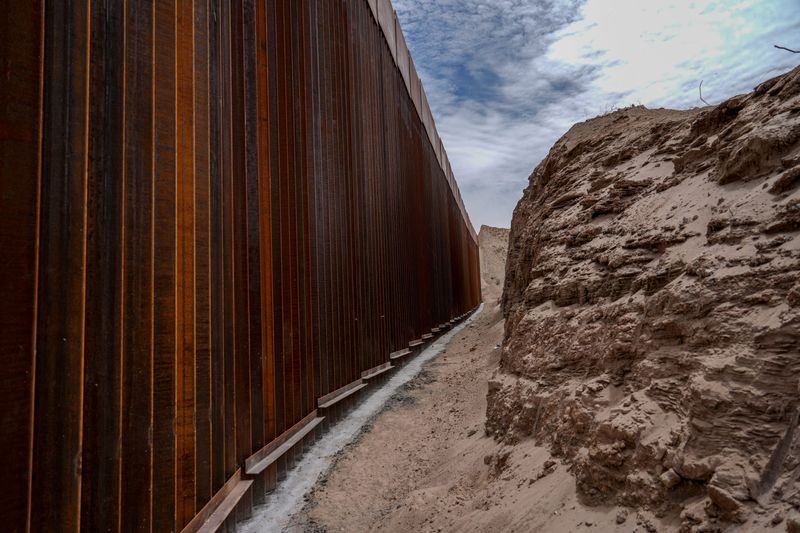 A border wall is seen where part of the rock was blasted for construction at the base of Mount Cristo Rey on April 29, 2026, as viewed from the Mexican side of the border.