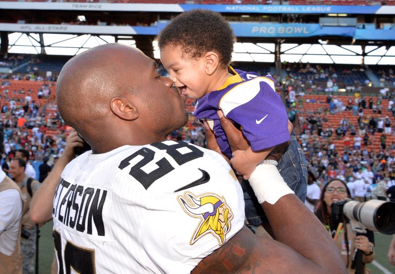 Jan 31, 2016; Honolulu, HI, USA; Team Rice running back Adrian Peterson of the Minnesota Vikings (28) kisses his son during the 2016 Pro Bowl at Aloha Stadium. Mandatory Credit: Kirby Lee-USA TODAY Sports