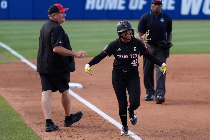 Texas Tech Red Raiders outfielder Mihyia Davis (42) celebrates with Texas Tech Red Raiders head coach Gerry Glasco after hitting a home run in the first inning of Game 1 of the NCAA softball Women's College World Series finals between the Texas Longhorns and the Texas Tech Red Raiders at Devon Park in Oklahoma City, Wednesday, June 3, 2026.