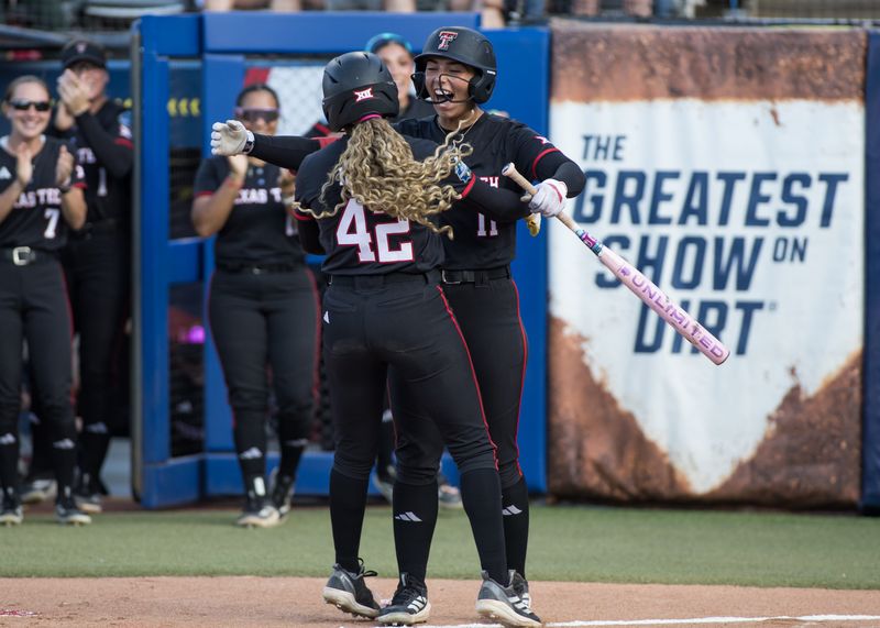 Jun 3, 2026; Oklahoma City, OK, USA; Texas Tech Red Raiders infielder Lauren Allred (11) hugs outfielder Mihyia Davis (42) after Davis’ home run in the first inning against the Texas Longhorns during Game One of the NCAA Women’s College World Series championship series at Devon Park. Mandatory Credit: Brett Rojo-Imagn Images