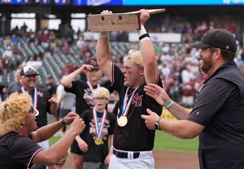 New Home's Ryder Starkey lifts the team's trophy after a win over Iola in the Class 2A Division I baseball state championship Thursday, June 4, 2026, at Dell Diamond in Round Rock.