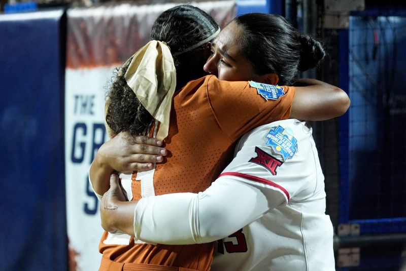 Texas Tech's Victoria Valdez (13) hugs Texas' Kayden Henry (21) following Game 2 of the NCAA softball Women's College World Series finals between the Texas Longhorns and the Texas Tech Red Raiders at Devon Park in Oklahoma City, June 4, 2026.