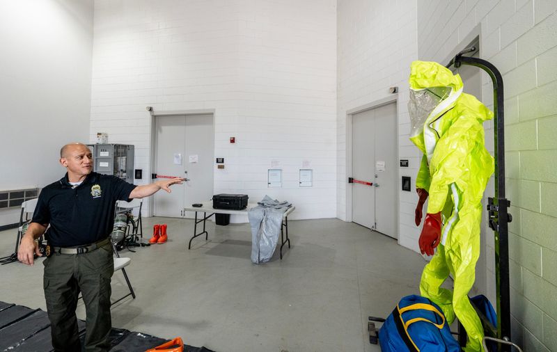 DEA El Paso Assistant Special Agent in Charge Jeffery Castillo points to a full-body protective suit while explaining the equipment agents must use in perilous environments during a demonstration in El Paso, Texas.