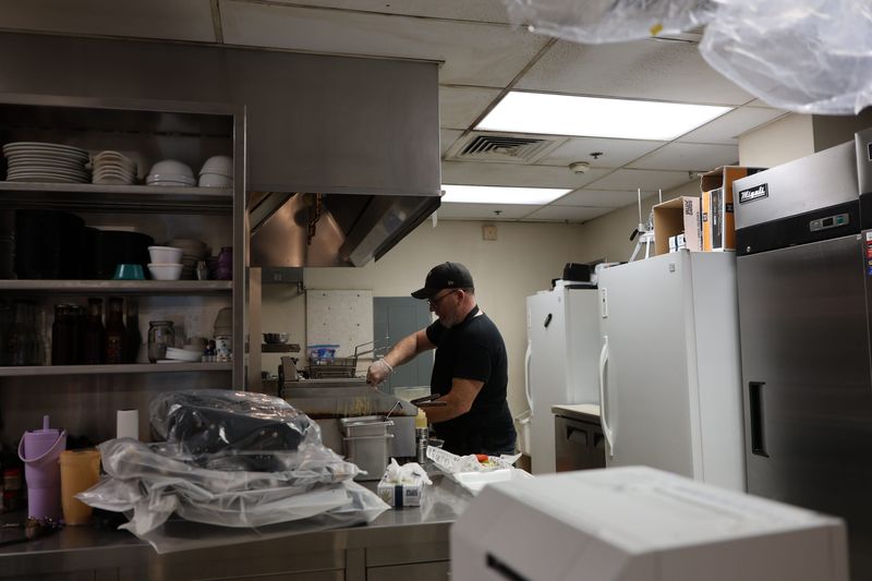 City Cafe's Shaun Sechrist finishes up a hamburger. He not only creates the menu, gathers the groceries and does prep work; he cooks and mingles with customers.