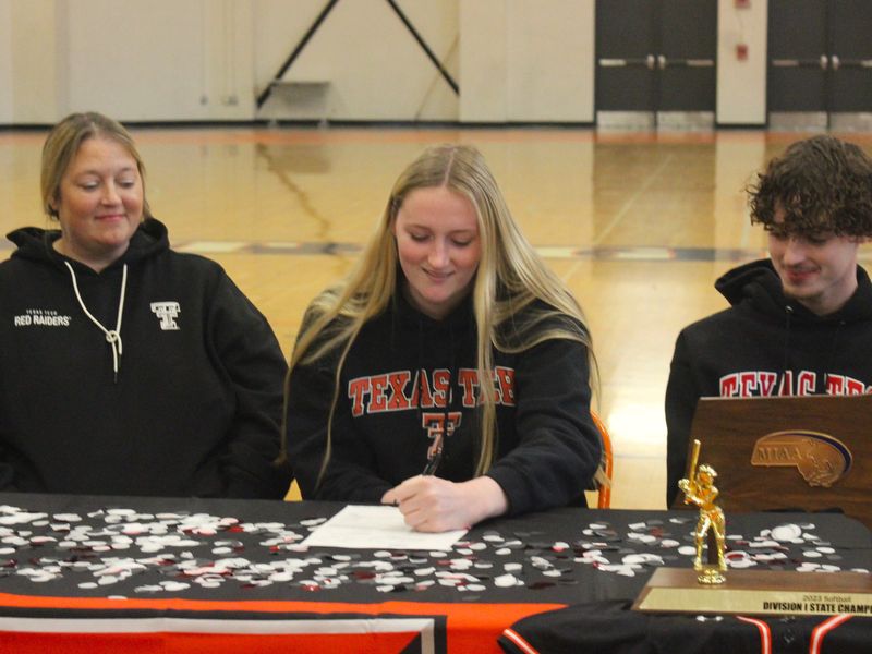 Taunton softball senior Sam Lincoln, with mom Michelle Lincoln (left) and brother Brad Lincoln (right) watching on, signs her National Letter of Intent committing to Texas Tech University during a signing ceremony at the Rabouin Field House on Nov. 8, 2023.