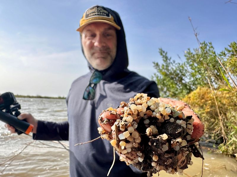 Jay Kleberg, of the Gulf Trust, holds a handful of nurdles from along the Victoria Barge Canal.