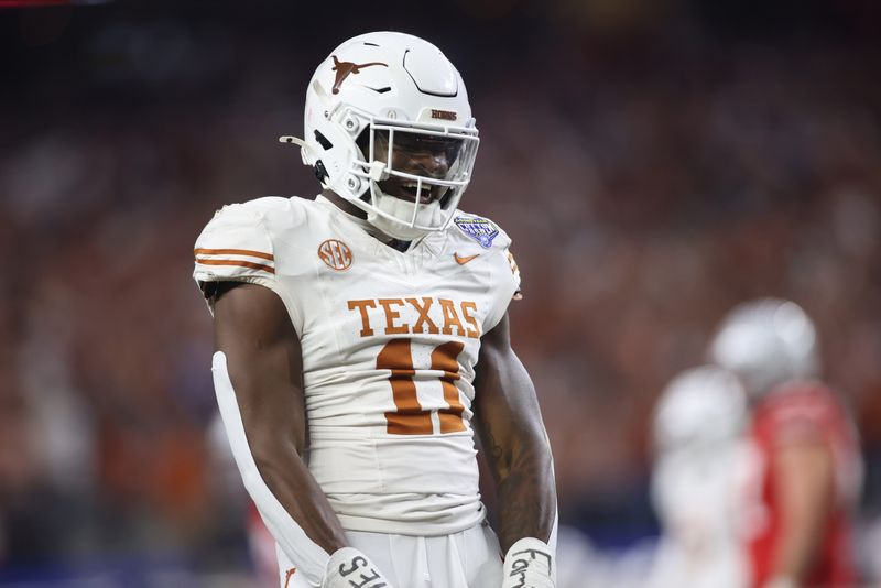 Jan 10, 2025; Arlington, Texas, USA; Texas Longhorns linebacker Colin Simmons (11) celebrates after a pass break up during the third quarter of the College Football Playoff semifinal against the Ohio State Buckeyes in the Cotton Bowl at AT&T Stadium. Mandatory Credit: Tim Heitman-Imagn Images