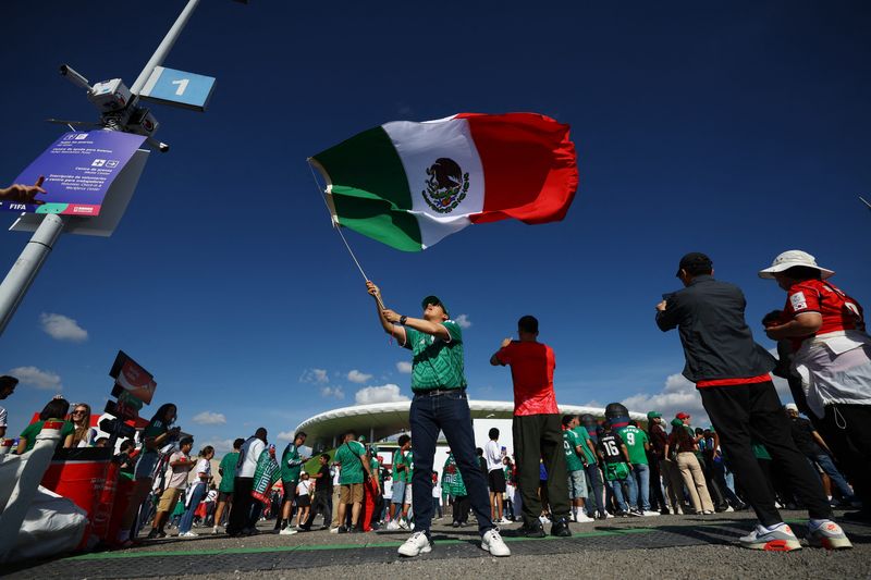 A Mexico fan waves their national flag outside the stadium before the match.