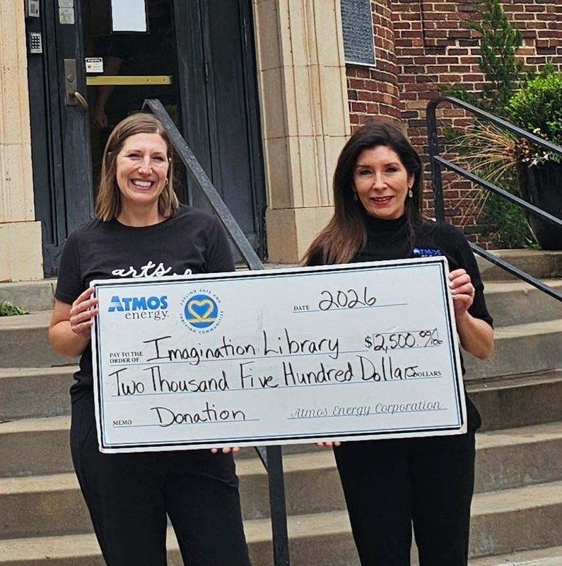 Arts Council Wichita Falls CEO Kristen Shiplet, left, and Atmos Energy Manager of Public Affairs Pam Hughes Pak Atmos Energy hold a $2,500 donation check from Atmos to the Arts Council for children’s literacy.