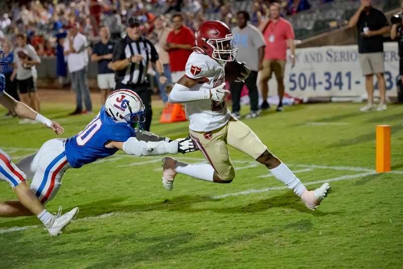Brother Martin Crusaders wide receiver Easton Royal (23) scores a touchdown against John Curtis Patriots linebacker Benjamin Barron (30) during the first quarter at The Shrine on Airline. Mandatory Credit: Matthew Hinton-USA TODAY Sports