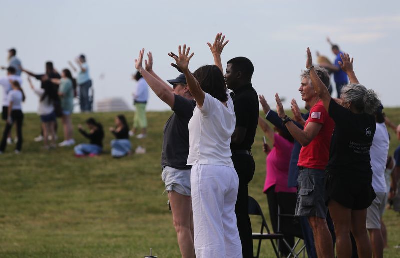 Attendants raise their hands in prayer at a gathering in Cole Park in Corpus Christi on July 8, 2026. The focus of the event was praising God for recent rains and praying for more in the future.