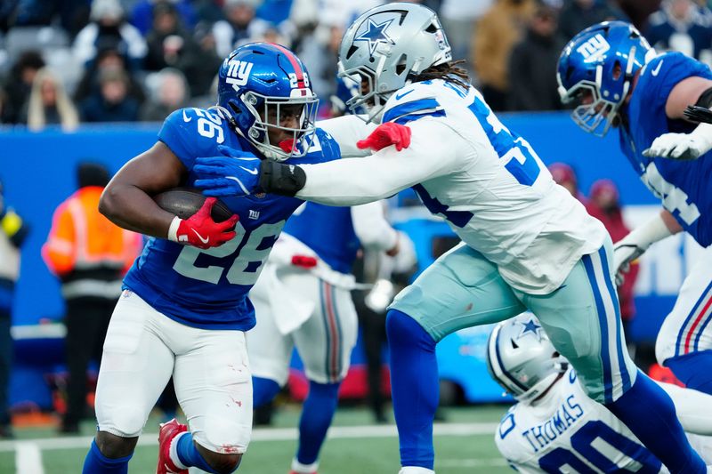 New York Giants running back Devin Singletary (26) tries to run past Dallas Cowboys defensive end Sam Williams (54), January 4, 2026, in East Rutherford.