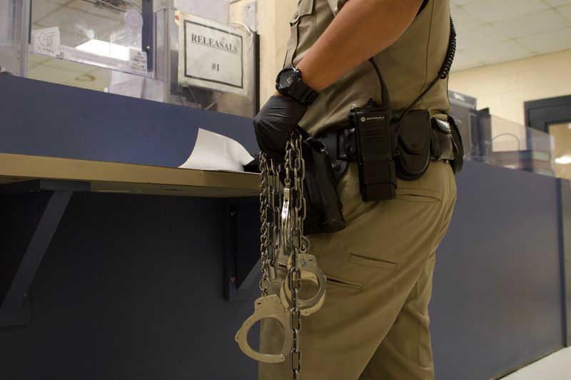 An officer holds multiple pairs of handcuffs at the Nueces County Jail on July 22.