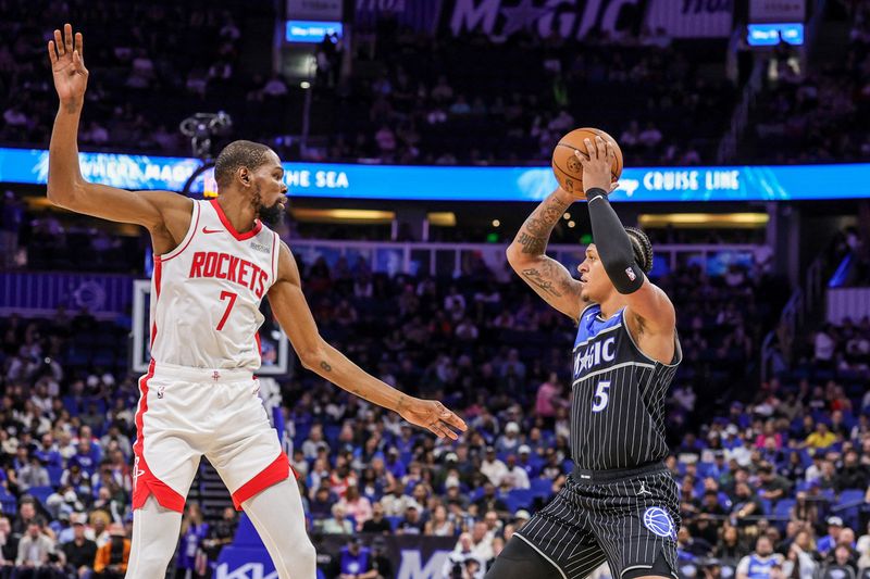 Feb 26, 2026; Orlando, Florida, USA; Orlando Magic forward Paolo Banchero (5) passes in front of Houston Rockets forward Kevin Durant (7) during the first quarter at Kia Center. Mandatory Credit: Mike Watters-Imagn Images
