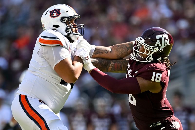 Sep 27, 2025; College Station, Texas, USA; Texas A&M Aggies defensive end T.J. Searcy (18) attempts to rush the edge as Auburn Tigers offensive lineman Mason Murphy (76) blocks during the second quarter at Kyle Field. Mandatory Credit: Maria Lysaker-Imagn Images