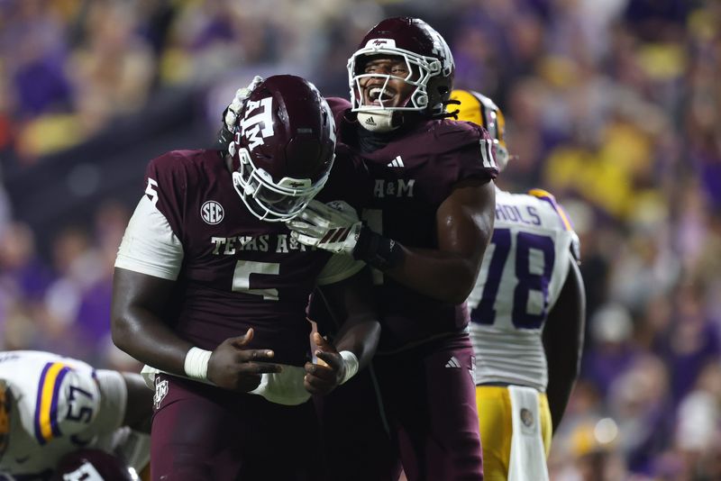 Oct 25, 2025; Baton Rouge, Louisiana, USA; Texas A&M Aggies defensive tackle DJ Hicks (5) celebrates with defensive tackle Tyler Onyedim (11) after a play during the second half against the Louisiana State Tigers at Tiger Stadium. Mandatory Credit: Stephen Lew-Imagn Images