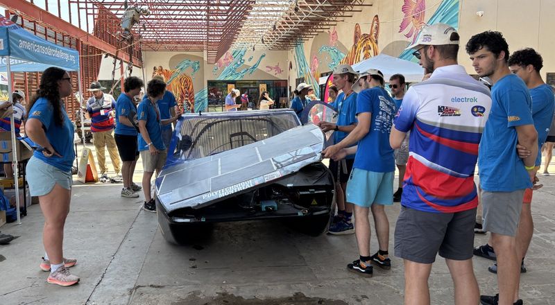 Raising the "hood" of a solar car to expose few mechanical parts undermeath. Solar panels cover the tops of the solar cars to draw energy from the sun in the experimental cars.