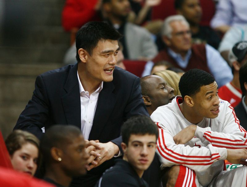 Houston Rockets center Yao Ming (L), sidelined for the rest of the season with a foot injury, watches from the bench with teammate Gerald Green during the first half of their NBA basketball game against the Washington Wizards in Houston February 26, 2008.    REUTERS/Richard Carson  (UNITED STATES)