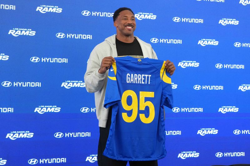 Jun 2, 2026; Woodland Hills, CA, USA; Los Angeles Rams defensive end Myles Garrett (95) poses with jersey at press conference at Rams Practice Facility. Mandatory Credit: Kirby Lee-Imagn Images