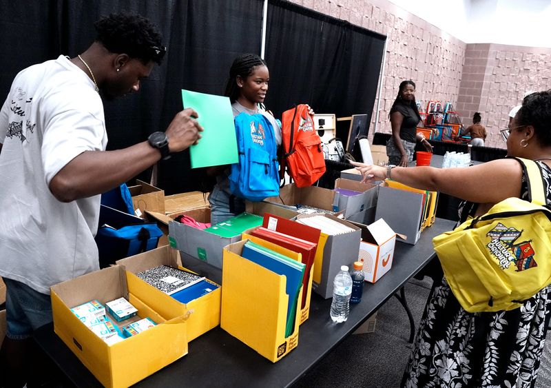 Johnny White (left) and Alana Latin hand out backpacks to families during Kulture Con Saturday at the Abilene Convention Center Aug. 1, 2026. The event was organized as a celebration of diverse cultures and community.