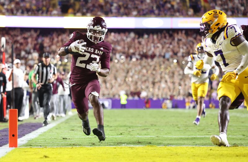 Oct 25, 2025; Baton Rouge, Louisiana, USA; Texas A&M Aggies running back Jamarion Morrow (23) runs for a touchdown against Louisiana State Tigers linebacker Harold Perkins Jr. (7) during the second half at Tiger Stadium. Mandatory Credit: Stephen Lew-Imagn Images