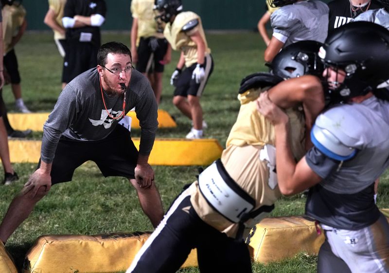 Haskell High School defensive coordinator Quenton Patterson observes the tackling technique of two players early Saturday Aug. 8, 2026. Midnight Madness marked the team’s first practice of the fall season, drawing a crowd of nearly 200 to watch and support the Indians.