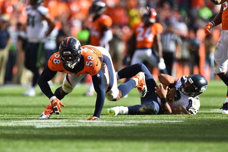Sep 9, 2018; Denver, CO, USA; Denver Broncos outside linebacker Von Miller (58) crawls after sacking Seattle Seahawks quarterback Russell Wilson (background) for his 50th career sack against in the fourth quarter at Broncos Stadium at Mile High. Mandatory Credit: Ron Chenoy-USA TODAY Sports