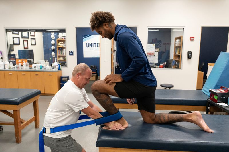 Cash Cheeks performs joint mobilization exercises with C.J. Potter, assistant athletic director for sports medicine, in UTEP's sports medicine facility as the tight end prepares for the 2026 season after missing 2025 with a broken fibula.