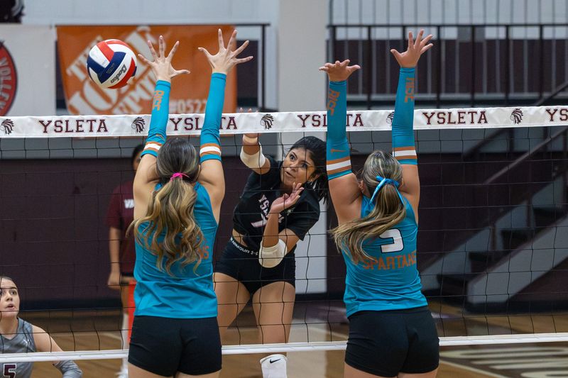 Ysleta’s junior Abigale Martinez hits the ball over the net as two Pebble Hills players jump to block the shot during the varsity volleyball matchup on Aug. 18, 2026, at the Ysleta High School gym.