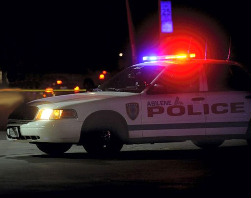 An Abilene police car flashes lights during night.