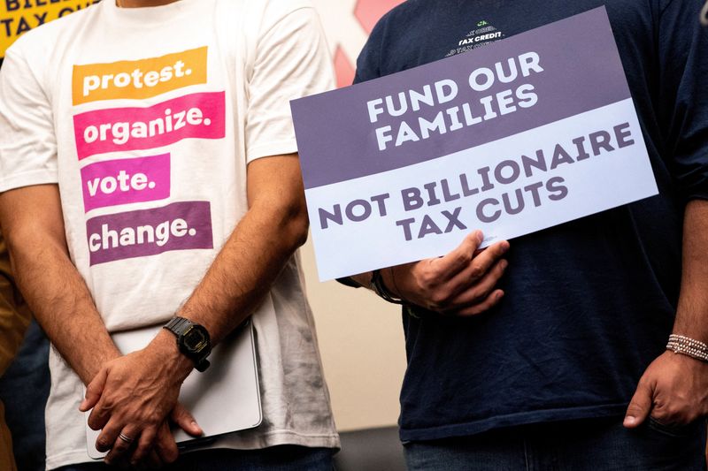 FILE PHOTO: Demonstrators hold signs during a press conference to discuss cuts to Medicaid, the Supplemental Nutrition Assistance Program (SNAP) and the Child Tax Credit, on Capitol Hill in Washington, D.C., U.S., May 13, 2025. REUTERS/Nathan Howard/File Photo
