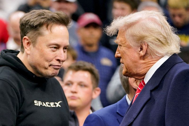 FILE PHOTO: Tesla CEO Elon Musk greets U.S. President Donald Trump as they attend the NCAA men's wrestling championships in Philadelphia, Pennsylvania, U.S., March 22, 2025. REUTERS/Nathan Howard/File Photo