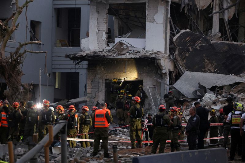 Emergency personnel work at an impact site following a missile attack from Iran on Israel, in Tel Aviv, Israel, June 16, 2025. REUTERS/Ronen Zvulun
