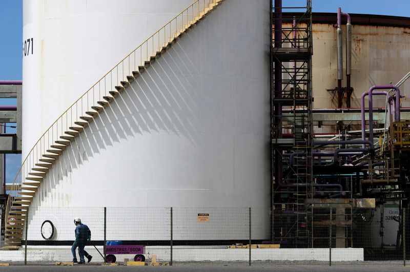 FILE PHOTO: Workers pass in front of a tank at a chlorine-soda plant of the petrochemical company Braskem in Maceio, Brazil January 30, 2020. Picture taken January 30, 2020. REUTERS/Amanda Perobelli/File Photo